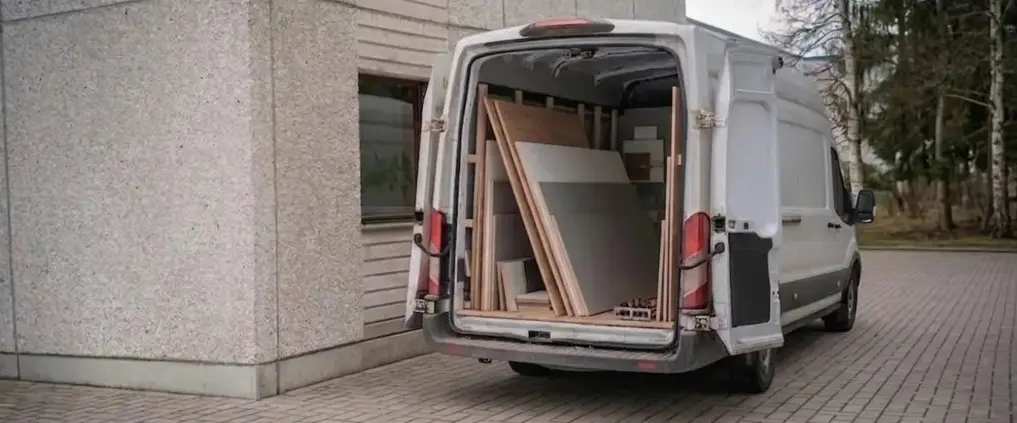 Twee verhuizers laden ingepakt spuitwerk in de bakwagen